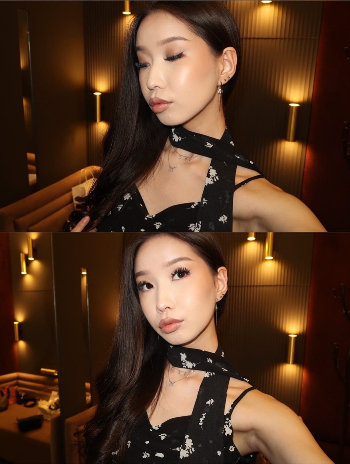 A woman poses in a warmly lit room wearing a black floral halter top with a neck tie, with wall sconces and a bed visible behind her.